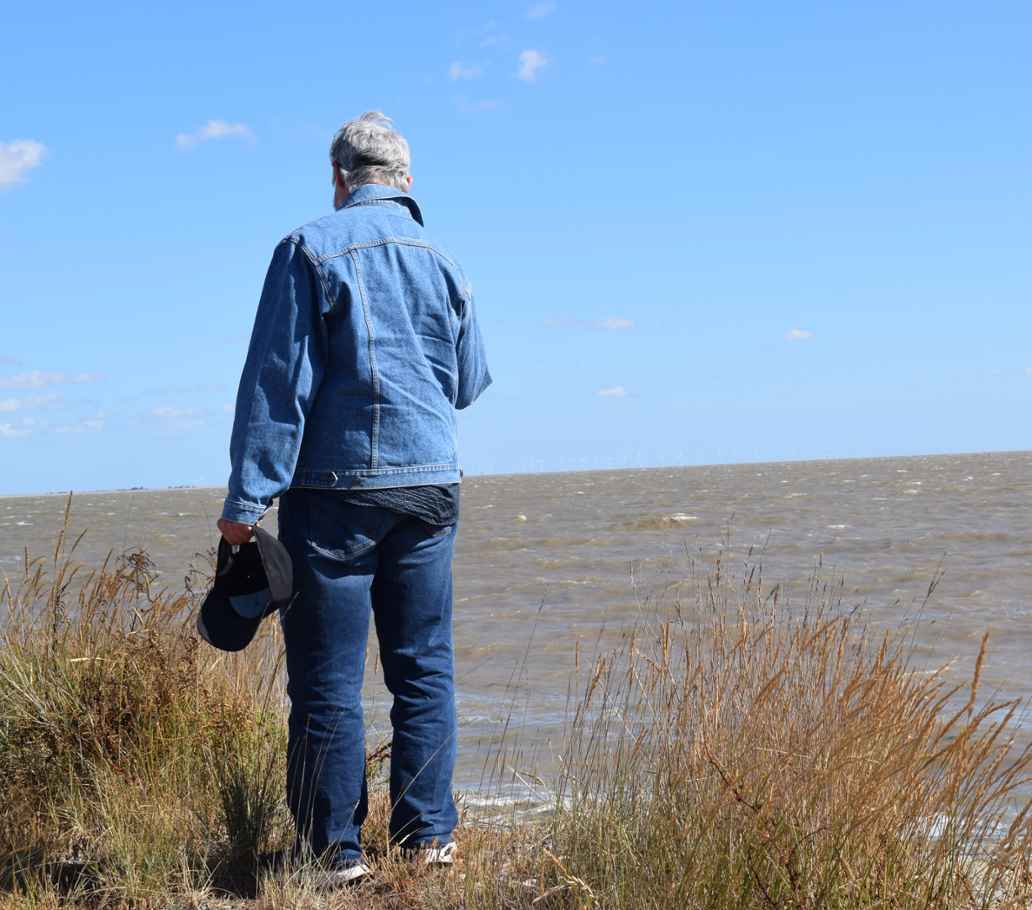 Man looking out to sea on Mersea Island (Essex)