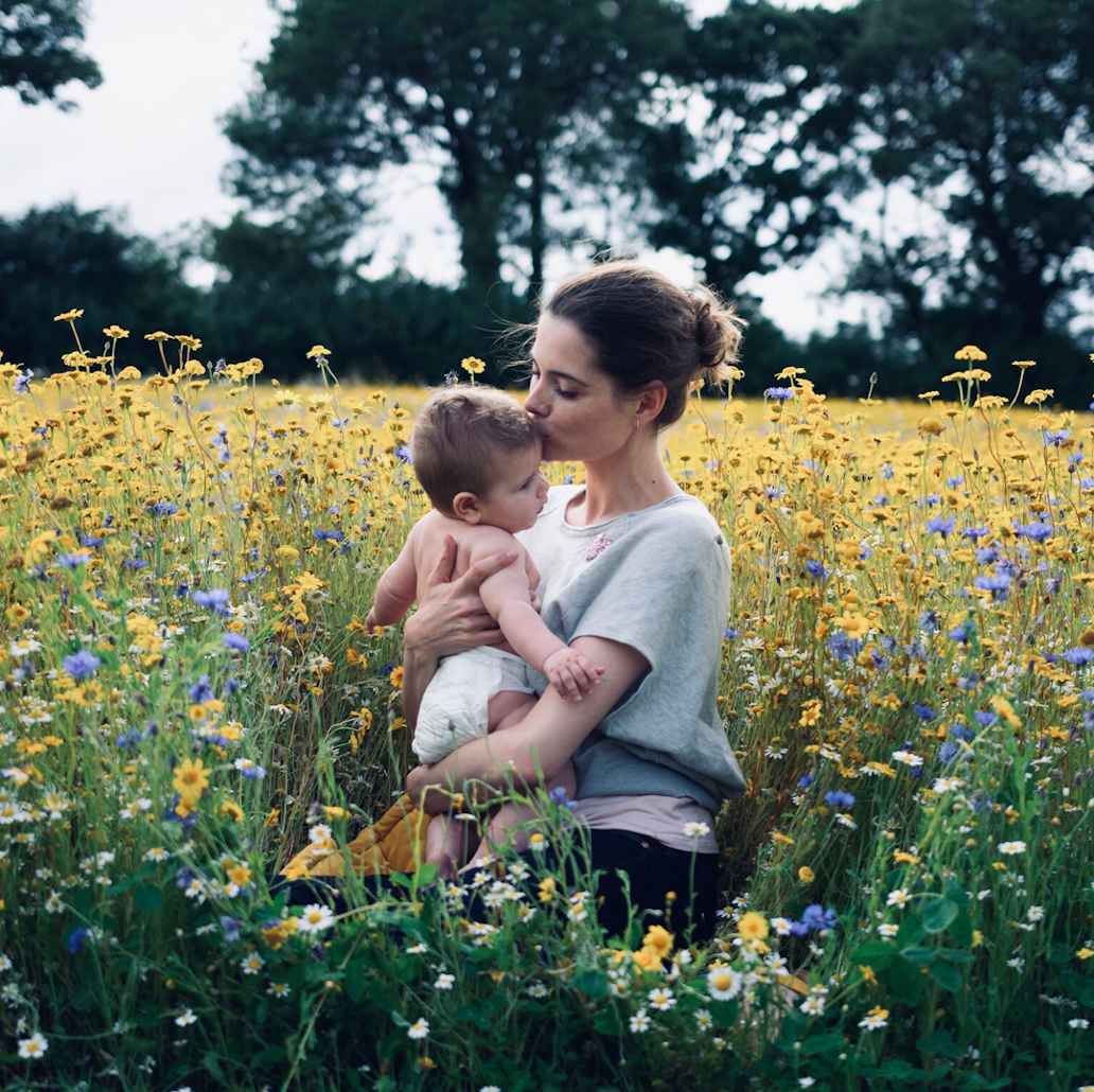 Promotional imagery for Mama Bamboo, featuring a mother and baby in a field of flowers.